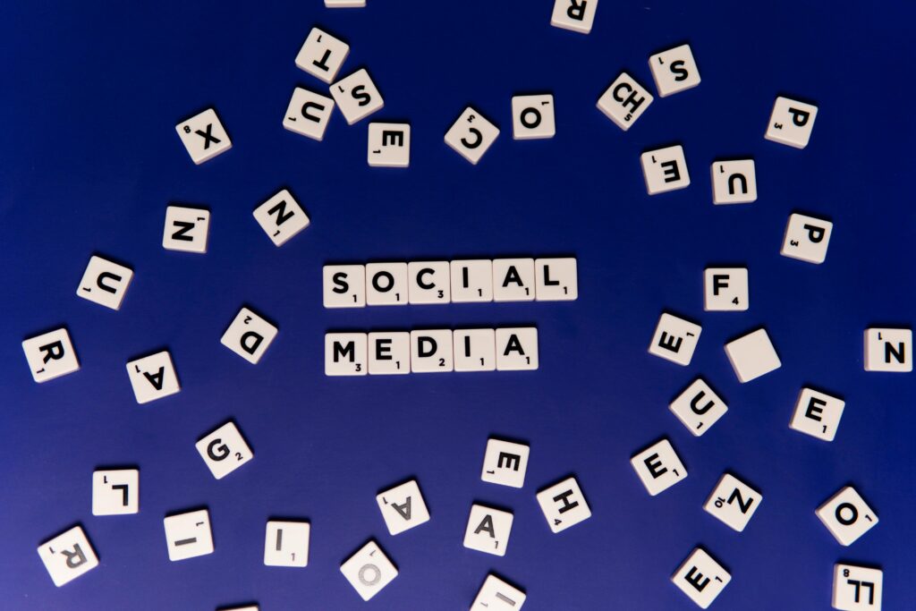 Scrabble tiles spelling 'Social Media' on a blue background, ideal for digital marketing themes.